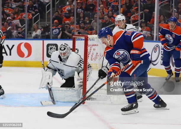 Zach Hyman of the Edmonton Oilers moves the puck to the front of the net in overtime as Joonas Korpisalo of the Los Angeles Kings watches in Game One...