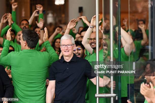 Chief Executive Officer of Apple Tim Cook looks on as Apple employees cheer during the opening of Apple's first retail store in India in Mumbai on...