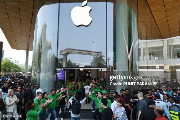 Apple employees cheer as they welcome customers during the opening of Apple's first retail store in India, in Mumbai on April 18, 2023. - Apple...