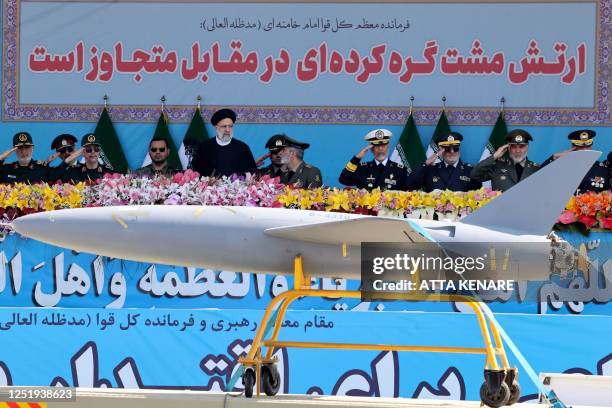 Iran's President Ebrahim Raisi watches combat drones alongside high-ranking officials and commanders during a military parade marking the country's...