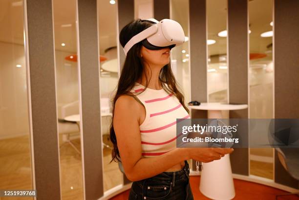 Customer wears a Meta Platforms Inc. Oculus Quest 2 virtual reality headset to demonstrate an immersive experience of BPI banking services inside the...