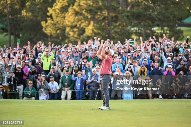 Jon Rahm of Spain puts his arms up in celebration in front of patrons after his four stroke victory on the 18th hole green during the final round of...