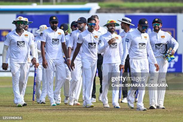 Sri Lanka's captain Dimuth Karunaratne with teammates walk back to the pavilion after Sri Lanka won by an innings and 280 runs during the third day...