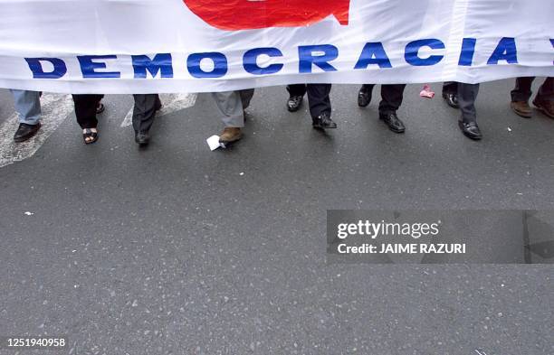 Dirigentes sindicales llevan una banderola con la inscripcion "democracia" durante una marcha de protesta, el 06 Enero de 2000, en contra de la...