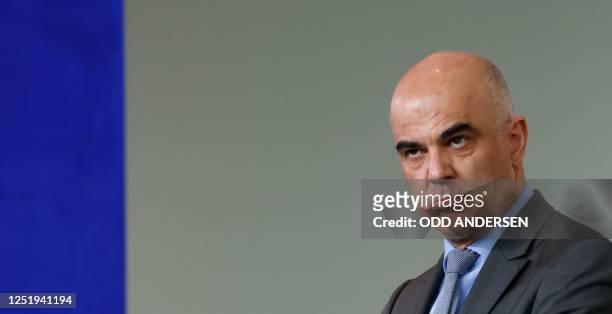 Swiss President Alain Berset listens as the German Chancellor speaks during a joint press conference after talks at the Chancellery in Berlin on...