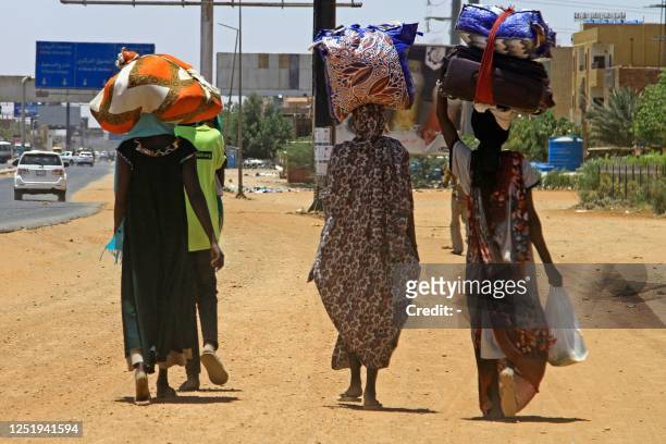 People flee from southern Khartoum on April 18, 2023 as fighting between the army and paramilitary forces led by rival generals rages for a fourth...