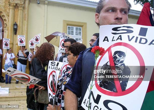 Costa Rican citizens hold signs 31 October 2002 during a demonstration against war, in front of the chancellors office in San Jose, Costa Rica....