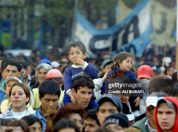 Demonstrators, some of them carrying their children, march towards the Plaza de Mayo in Buenos Aires, 20 June 2002. AFP PHOTO ALI BURAFI....