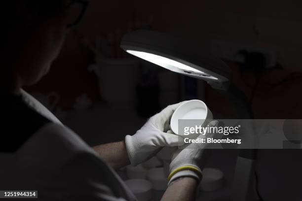 Worker inspects fine bone china in the quality control department at the Halcyon Days Ltd. Factory in Stoke-on-Trent, UK, on Monday, April 17, 2023....