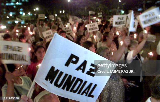 People hold candles outside the US embassy 14 March 2003 in Lima, Peru, during a protest against the possible US military invasion of Iraq. Anti-war...