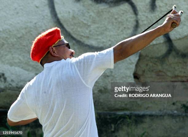 Demonstrator throws stones against opponents of Hugo Chavez with a sling shot during a demonstration in Caracas, 14 January, 2003. Un manifestante...