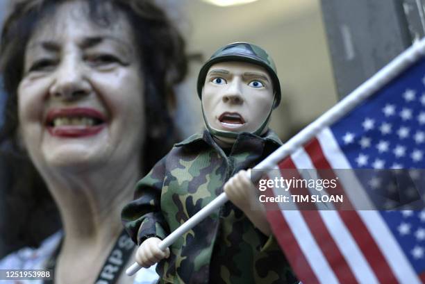 An anti-Bush protester holds an action figure as she demonstrate 29 August 2004, in New York City.Thousands of protesters, led by filmmaker Michael...