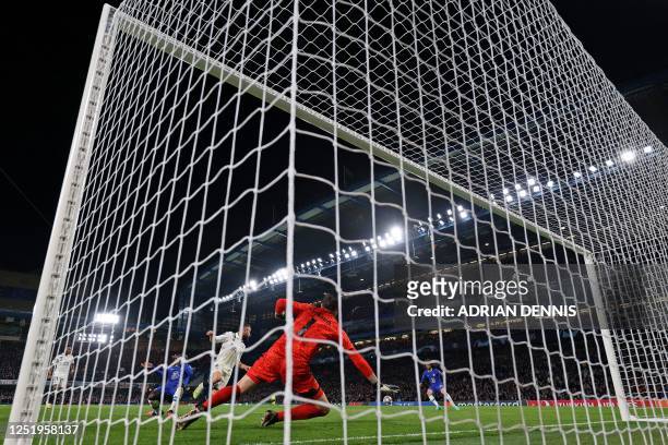 Real Madrid's Belgian goalkeeper Thibaut Courtois dives to save a shot by Chelsea's Spanish defender Marc Cucurella during the Champions League...