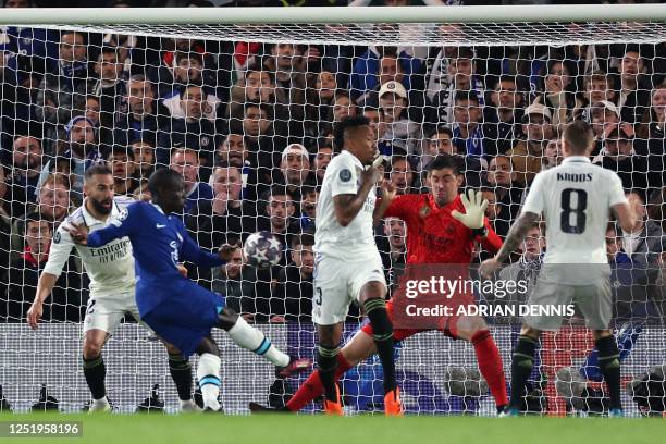 Real Madrid's Belgian goalkeeper Thibaut Courtois saves a shot from Chelsea's French midfielder N'Golo Kante during the Champions League...