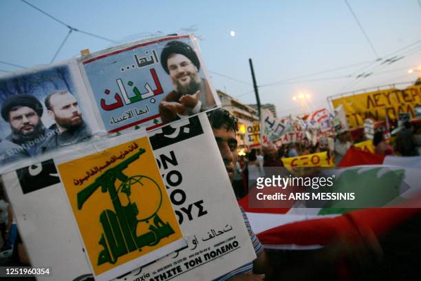 Protestor holds a poster with portraits of Lebanon's Hezbollah leader Sheikh Hassan Nasrallah in front of the Israeli embassy in Athens 03 August...