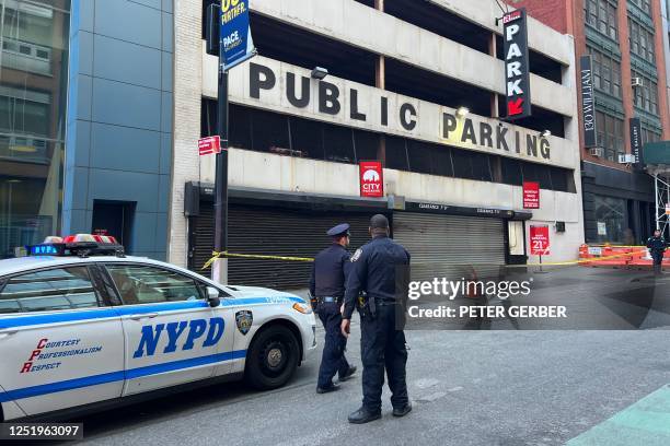 New York Police Department officers are seen at the scene of a parking garage that collapsed in lower Manhattan, New York City, on April 18, 2023. -...