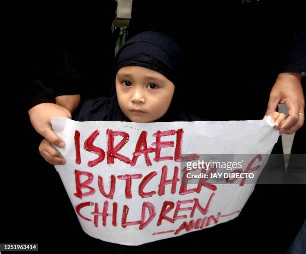 Three-year-old Filipino Muslim Sarah Piang holds a placard during an anti-war protest outside the Israeli embassy in Manila, 08 August 2006. The...