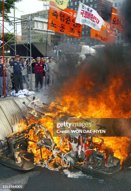 Some of the more than 1,000 protesters burn a tractor during a rally to oppose a free trade agreement between South Korea and Chile, 20 June 2003, in...