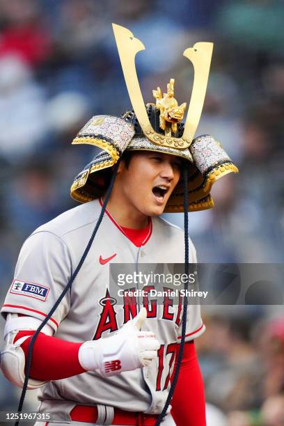 Shohei Ohtani of the Los Angeles Angels wears the Angels' new home run hat, a custom Samurai Kabuto helmet, after hitting a two-run home run in the...