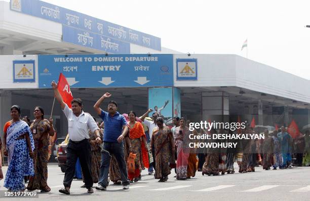 Indian airport workers shout slogans as they take part in a protest march outside the international terminal building of Netaji Subhash Chandra Bose...