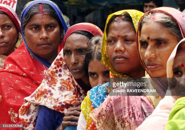 Indian women from poor families shout anti-Prime Minister Manmohan Singh and anti-Congress-led United Progressive Alliance government slogans during...