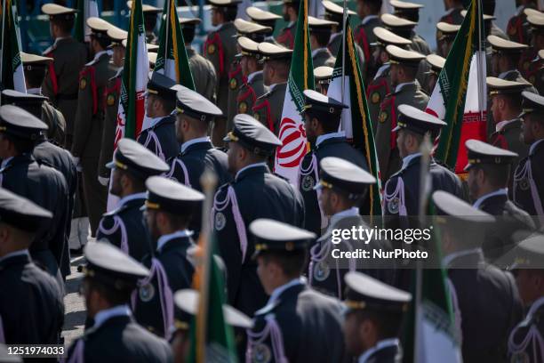 Members of an Iranian Army honor guard stand at attention with Iran's flags during a military parade marking Iran's Army Day anniversary near the...