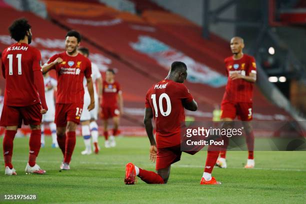 Sadio Mane of Liverpool celebrates by taking a knee after he scores his sides fourth goal during the Premier League match between Liverpool FC and...