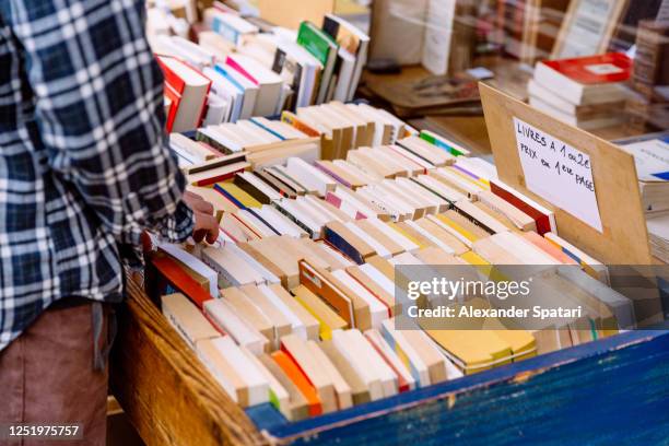 man choosing books outside of a book shop in paris, france - day imagens e fotografias de stock