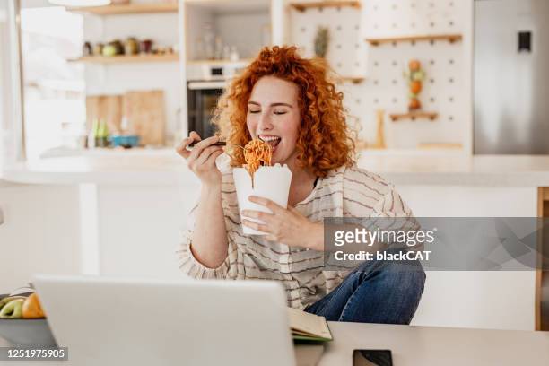 work from home and lunch break - woman junk food eating stock pictures, royalty-free photos & images