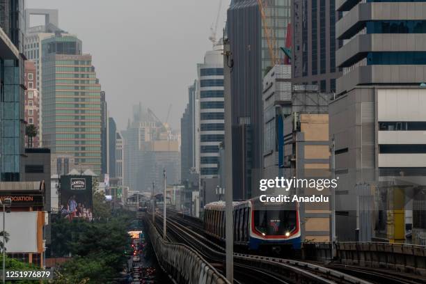 Thick cloud of PM2.5 fog is seen behind a Bangkok Skytrain car as it arrives at a station during morning rush hour in Bangkok, Thailand on April 19,...