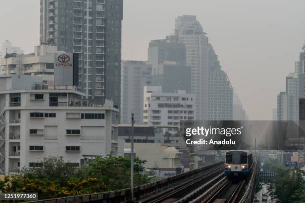 Thick cloud of PM2.5 fog is seen behind a Bangkok Skytrain car as it arrives at a station during morning rush hour in Bangkok, Thailand on April 19,...