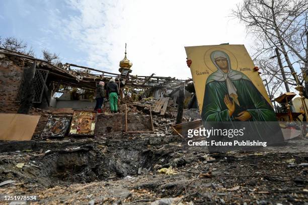 Man carries an icon slavaged on the ruins of the Church of Saint Michael the Archangel built in 1906 after Russian invaders launched S-300 rockets on...