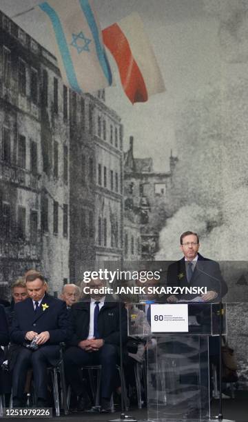Polish President Andrzej Duda listens as Israel's President Isaac Herzog delivers a speech during the central commemoration of the 80th anniversary...