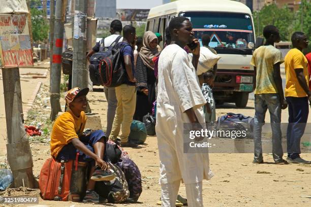 People wait for a bus to flee from southern Khartoum on April 18, 2023 as fighting between the army and paramilitary forces led by rival generals...