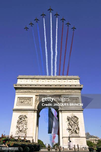 Nine Alphajets from the French Air Force's Patrouille de France, or French Acrobatic Patrol, fly in their arrow formation over the Arc de Triomphe...