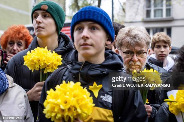 People hold bouquets of daffodils as they take part in unofficial ceremonies to mark the 80th anniversary of the start of the Warsaw Jewish Ghetto...