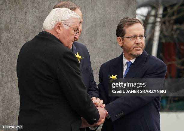 German President Frank-Walter Steinmeier , Polish President Andrzej Duda , and Israel's President Isaac Herzog hold hands together after laying...