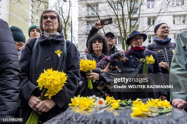 People hold bouquets of daffodils as they take part in unofficial ceremonies to mark the 80th anniversary of the start of the Warsaw Jewish Ghetto...