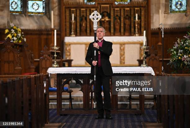 Archbishop of Wales, Andrew John poses with 'The Cross of Wales' ahead of a ceremony to bless the Cross at Holy Trinity Church in Llandudno, north...