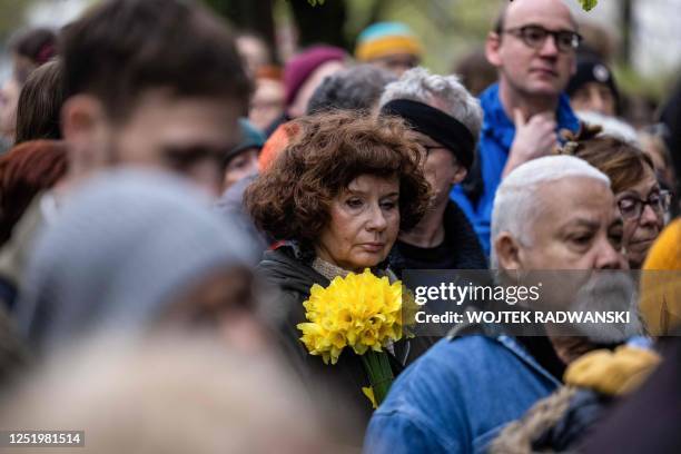 Woman holds a bouquet of daffodils as they take part in unofficial ceremonies to mark the 80th anniversary of the start of the Warsaw Jewish Ghetto...