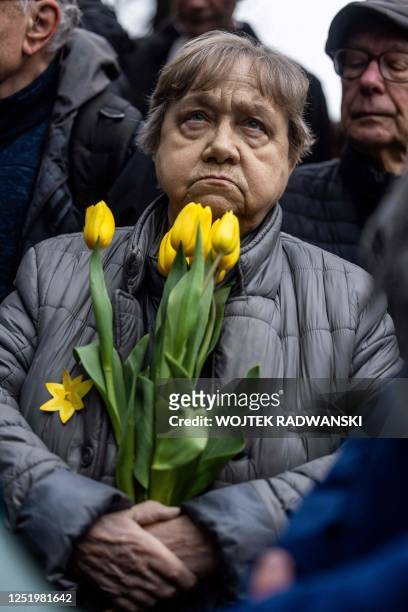 Woman holds a bouquet of tulips during unofficial ceremonies to mark the 80th anniversary of the start of the Warsaw Jewish Ghetto Uprising, Warsaw,...