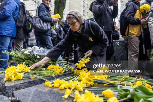 People lay daffodils in front of the Szmul Zygielbojm Monument as they take part in unofficial ceremonies to mark the 80th anniversary of the start...