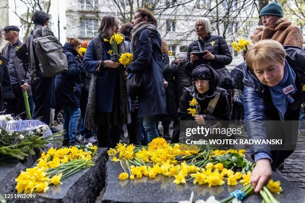 People lay daffodils in front of the Szmul Zygielbojm Monument as they take part in unofficial ceremonies to mark the 80th anniversary of the start...