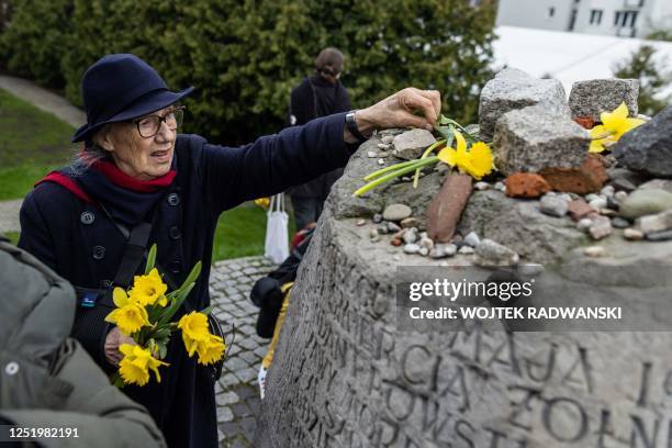 An elderly woman lays daffodils in front of Anielewicz bunker memorial as she takes part in unofficial ceremonies to mark the 80th anniversary of the...