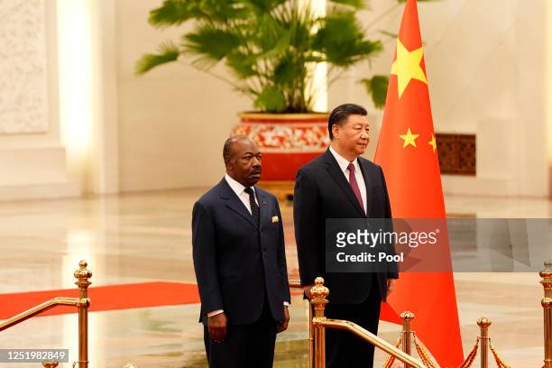 Gabonese President Ali Bongo Ondimba and Chinese President Xi Jinping inspect the honor guard during a welcome ceremony held at the Great Hall of the...