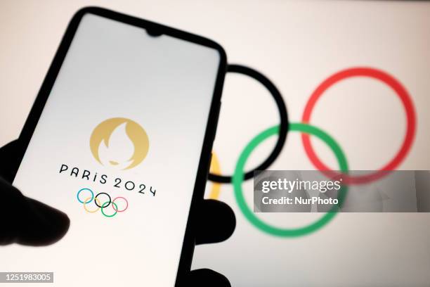 In this photo illustration a 2024 Summer Olympics logo is seen on a smartphone and Olympic rings on a computer screen in Athens, Greece on April 19,...