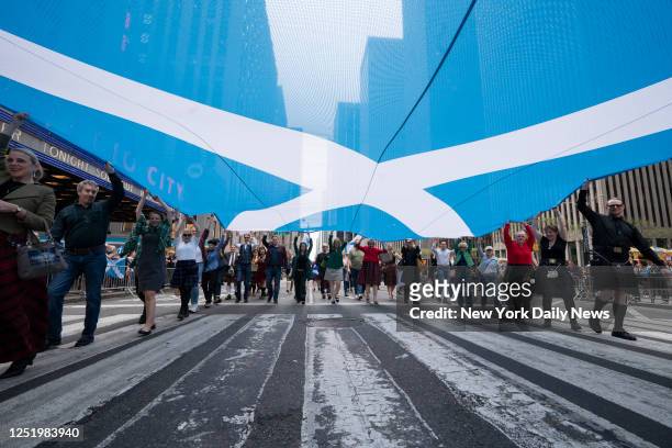 April 15: Marchers carry a Scottish flag during the 25th Annual Tartan Day Parade along Sixth Ave. Saturday, April 2023 in Manhattan, New York.
