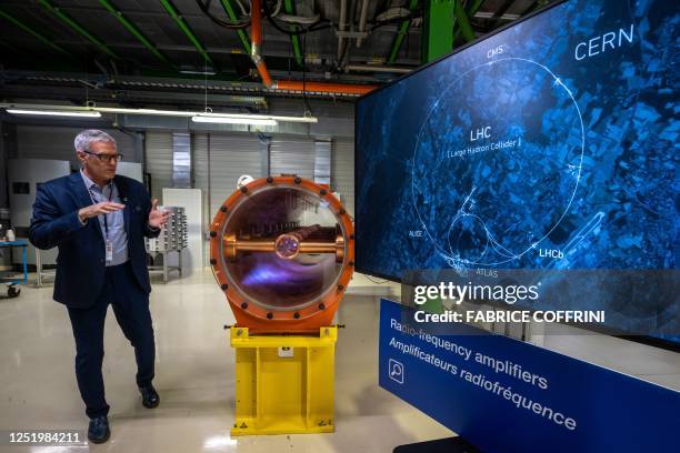 Radio-frequency head Eric Montesinos gestures next to a map of the actual Large Hadron Collider during a press trip at the European Organization for...