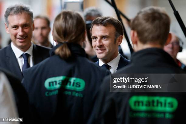 French President Emmanuel Macron speaks with Mathis CEO Frank Mathis and employees during a visit to Mathis, a company specialised in large wooden...