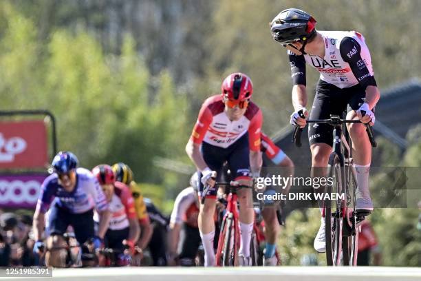 Slovenian Tadej Pogacar of UAE Team Emirates looks back as he crosses the finish line to win the 86th edition of the men's race 'La Fleche Wallonne',...